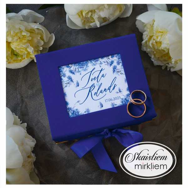 Karaliski zila gredzenu kastīte ar baltiem ziediem un vārdiem "Iveta un Rolands"