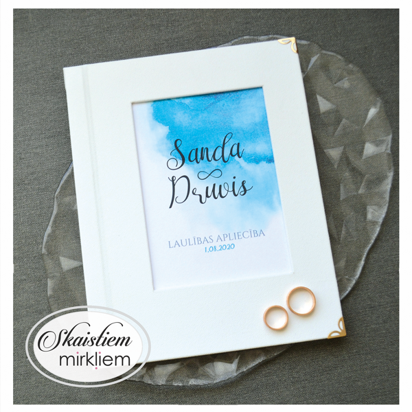 Balti laulības apliecības vāki ar zilu akvareli un vārdiem "Sanda un Druvis"