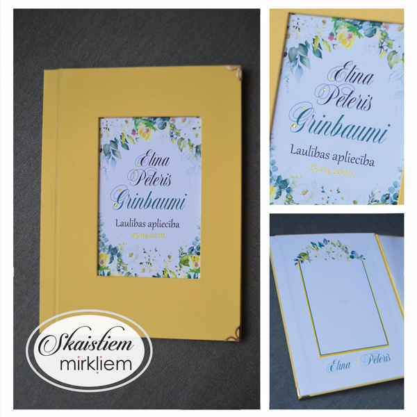 Dzeltenas krāsas laulības apliecības vāki ar ziedu motīvu un vārdiem "Elīna un Pēteris"