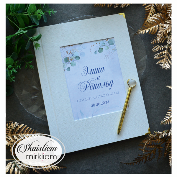 Pienbalti laulības apliecības vāki ar eikalipta lapām un vārdiem