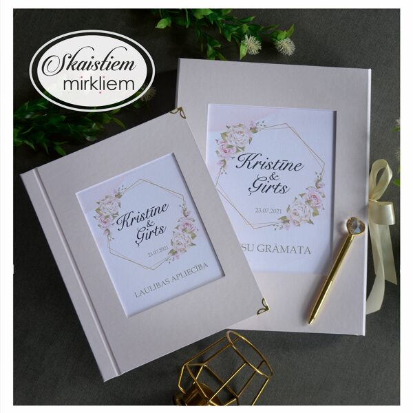 Puderrozā laulības apliecības vāki un viesu grāmata ar vārdiem "Kristīne un Ģirts"