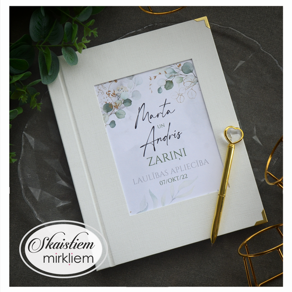 Krēmbalti laulības apliecības vāki ar zaļganu augu motīvu un vārdiem "Marta un Andris Zari