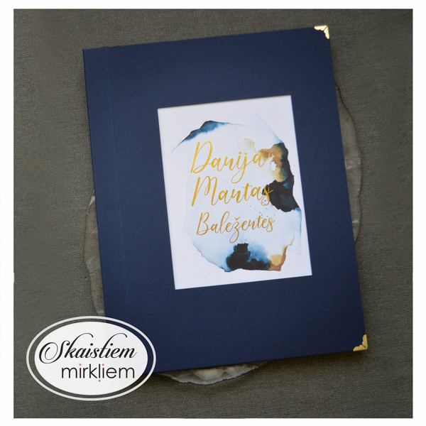 Tumši zila laulības apliecības vāki ar zelta vārdiem