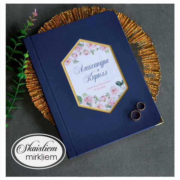 Tumši zilas krāsas laulības apliecības mape ar sešstūra rāmi, ziediem un vārdiem