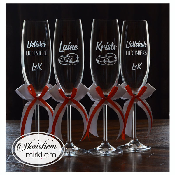 Personalizētas kāzu glāzes ar vārdu gravējumu un baltām, oranžām dekoratīvām lentēm