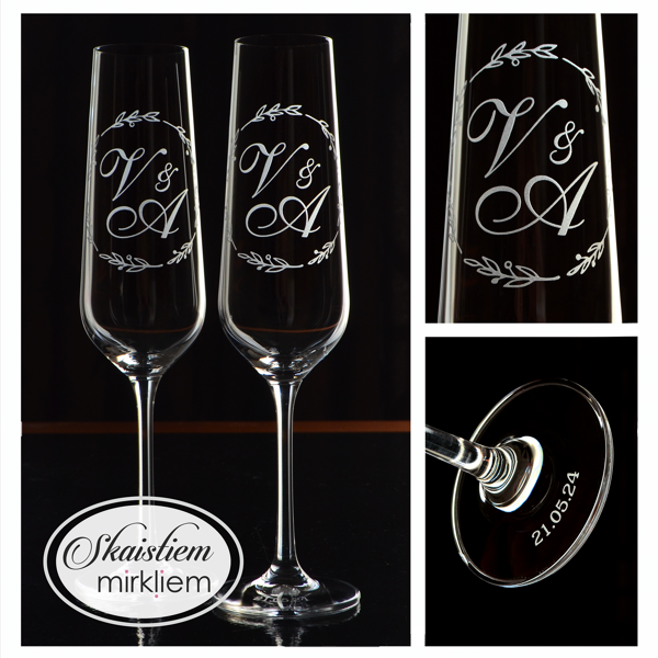 Elegants gravējums ar iniciāļiem V un A, ko ieskauj romantisks lapu vainags