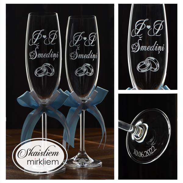 Elegants gravējums ar iniciāļiem I un I, uzvārdu, sirds motīvu un gaiši zillām lentēm