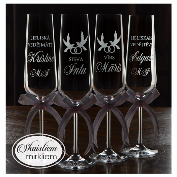 Kāzu glāzes ar dūju, savītu gredzenu un vārdu gravējumu un baltām lentēm