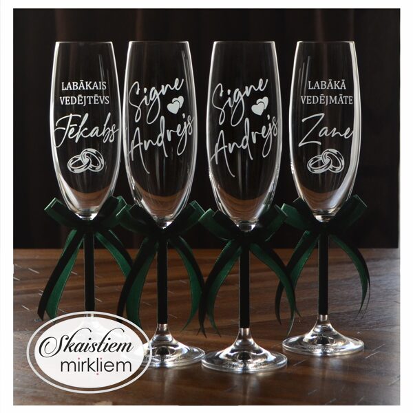 Kāzu glāzes ar gredzenu un sirds motīva gravējumu un tumši zaļām lentēm