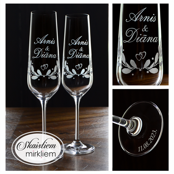 Elegants gravējums Arnim un Diānai ar lapu vītnēm un sirds simbolu kompozīcijas centrā