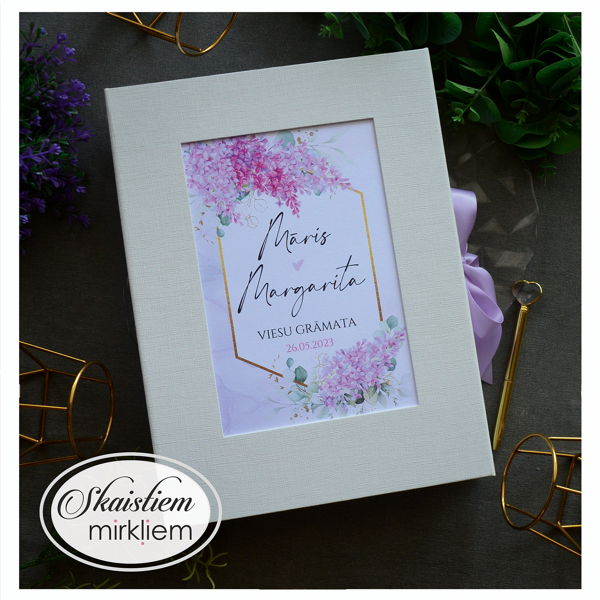 Gaiša viesu grāmata ar dažāda toņa violetas krāsas ceriņiem