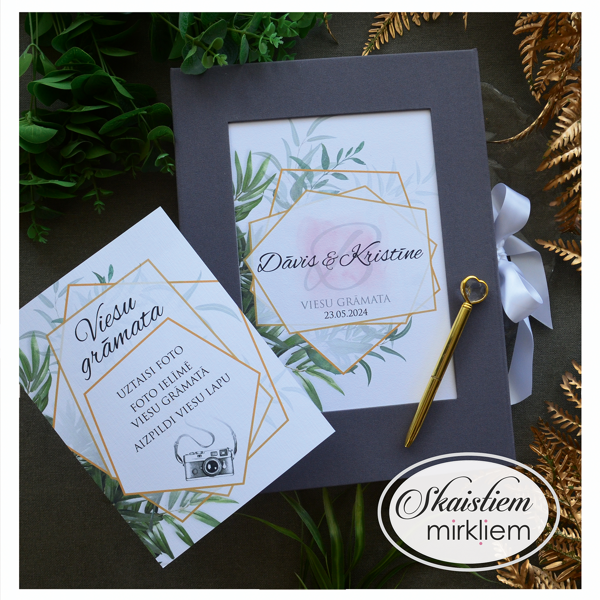 Tumši pelēka auduma viesu grāmata ar zelta rāmi, zaļumu printu un paskaidrojošu info