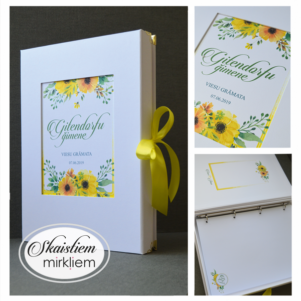 Balta viesu grāmata ar saulespuķu un zaļumu vainaga dizainu un koši dzeltenu lenti