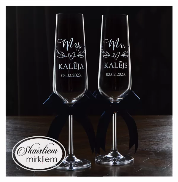 Kāzu glāzes ar gravējumu "Mr. Kalējs", "Mrs. Kalēja", datumu un zaļām dekoratīvām lentēm